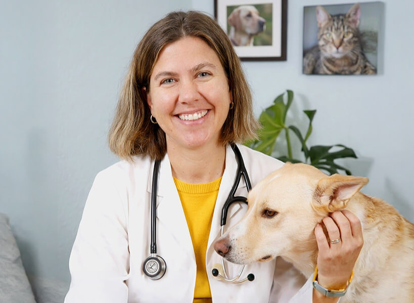 A vet smiling next to a dog